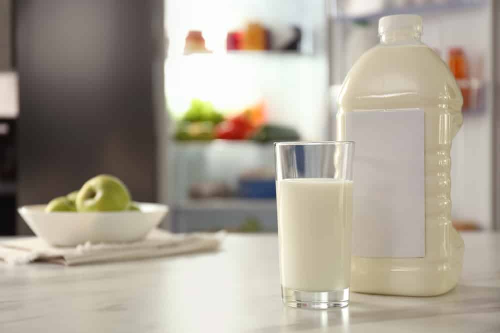 一加仑和一杯牛奶放在厨房的桌子上